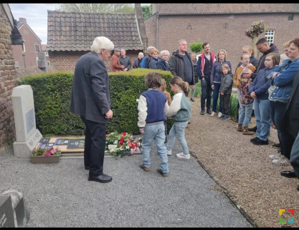 kinderen leggen bloemen op het graf van de soldaten